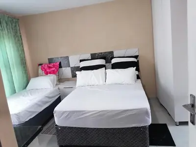 a bedroom with two beds with white and black pillows at Sibusisiwe 2 in Tasakani