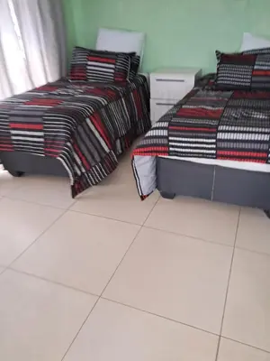 two beds sitting next to each other in a room at Sibusisiwe 2 in Tasakani