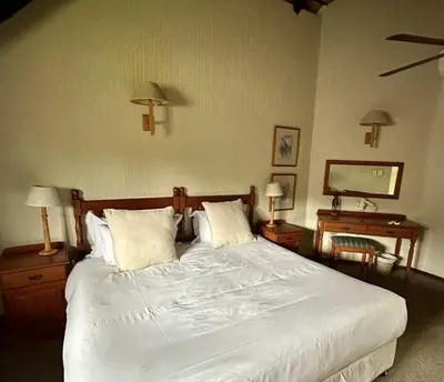 a bedroom with a large white bed with two night stands at Kruger Park Lodge - Unit 522 , Hazyview in Hazyview