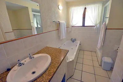 a bathroom with a sink and a toilet and a mirror at Kruger Park Lodge - Unit 522 , Hazyview in Hazyview