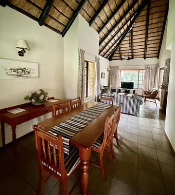 a dining room with a wooden table and chairs at Kruger Park Lodge - Unit 522 , Hazyview in Hazyview