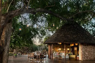 a pavilion with tables and chairs under a tree at Pafuri Camp by RETURN Africa in Makuleke Contract Park