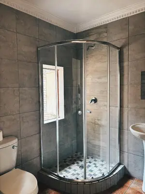 a shower with a glass door in a bathroom at Cozy stay in Kempton Park