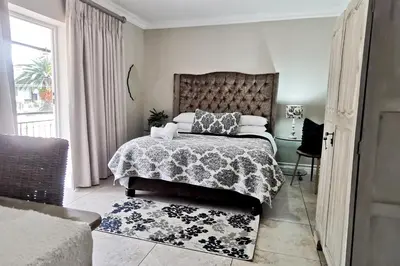 a bedroom with a large bed and a window at Bokmakierie Gastehuis Emalahleni Pty Ltd in Witbank