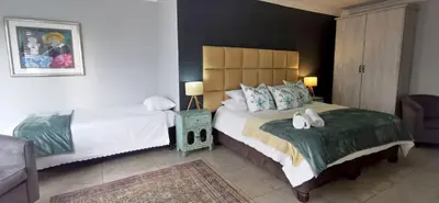 a bedroom with a large bed with two white towels on it at Bokmakierie Gastehuis Emalahleni Pty Ltd in Witbank