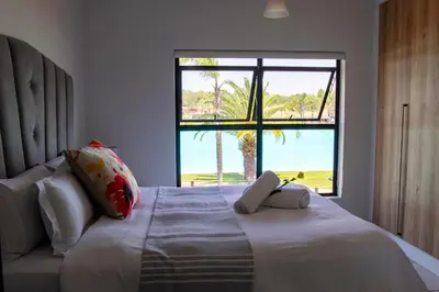 a bedroom with a large bed with a window at The Blyde 1471 in Pretoria