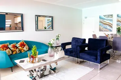 a living room with a blue couch and chairs at The Blyde 1471 in Pretoria