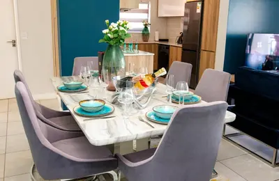 a dining room table with chairs and a vase of flowers at The Blyde 1471 in Pretoria