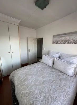 a bedroom with a large bed with white pillows at Bananas Den in Sandton