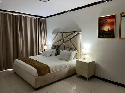 a bedroom with a bed and a night stand with a lamp at Lake view Apartment in Midrand