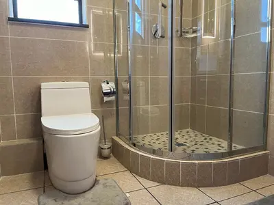 a bathroom with a shower with a toilet and a sink at Lake view Apartment in Midrand