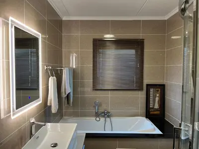 a bathroom with a tub and a sink at Lake view Apartment in Midrand