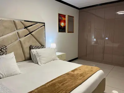 a bedroom with a large bed and a shower at Lake view Apartment in Midrand