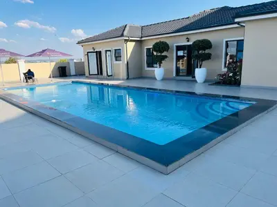 a large blue swimming pool in front of a house at Lake view Apartment in Midrand