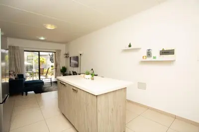 a kitchen with a island in the middle of a room at Mercy land Apartment 1 in Midrand