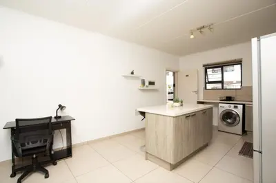 a kitchen with a desk and a washing machine at Mercy land Apartment 1 in Midrand