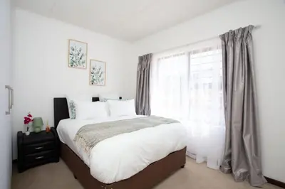 a bedroom with a large bed and a window at Mercy land Apartment 1 in Midrand