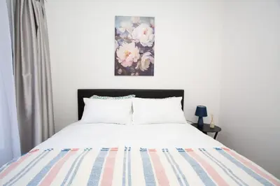 a bedroom with a bed and a painting on the wall at Mercy land Apartment 1 in Midrand