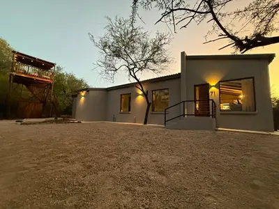 a house with a large driveway in front of it at The Duke Luxury Safari Villa, Huge Pool, Giraffe-Feeding-Tower, Outdoor Shower in Marloth Park