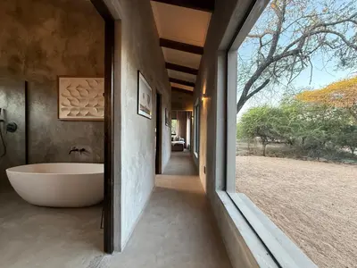 a bathroom with a tub and a window at The Duke Luxury Safari Villa, Huge Pool, Giraffe-Feeding-Tower, Outdoor Shower in Marloth Park