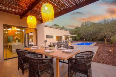 a dining room with a table and chairs at The Duke Luxury Safari Villa, Huge Pool, Giraffe-Feeding-Tower, Outdoor Shower in Marloth Park