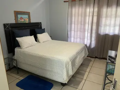 a bedroom with a large bed with white sheets at Pendleberry Grove Unit 8 in Bela-Bela