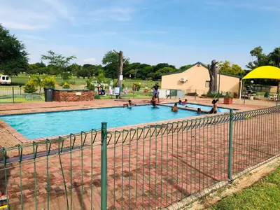 a swimming pool with people in it in a park at Pendleberry Grove Unit 8 in Bela-Bela