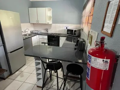 a kitchen with a red fire hydrant and a refrigerator at Pendleberry Grove Unit 8 in Bela-Bela