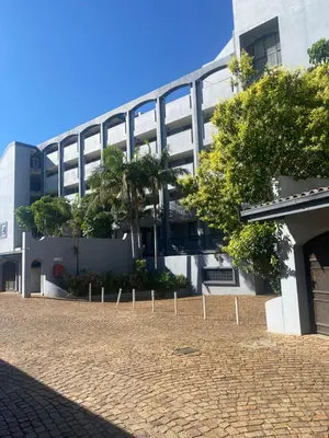 a building with a brick driveway in front of it at One Bedroom Apartment at Menlyn Place in Pretoria