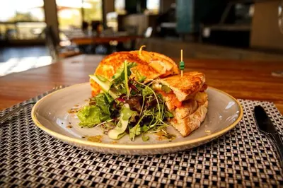 a sandwich and salad on a plate on a table at 522 The Regency Menlyn in Pretoria