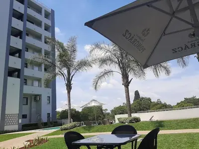 a table with chairs and an umbrella next to a building at 522 The Regency Menlyn in Pretoria