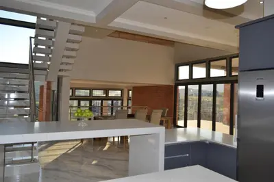 a kitchen with a white counter top and some windows at Mi Casa Su Casa Dullstroom luxury family Villa 12 sleeper in Dullstroom