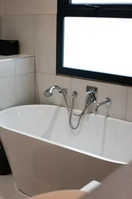 a bath tub with two faucets in a bathroom at Mi Casa Su Casa Dullstroom luxury family Villa 12 sleeper in Dullstroom