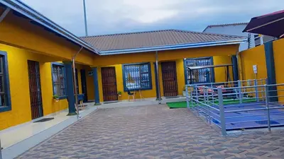 a yellow building with a gate in front of it at StayComfyGuesthouseByPunky in Soshanguve