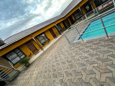 a building with a swimming pool in front of it at StayComfyGuesthouseByPunky in Soshanguve