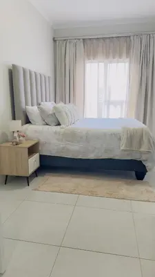 a bedroom with a large bed and a window at Luxury Apartment at 93 on New in Midrand