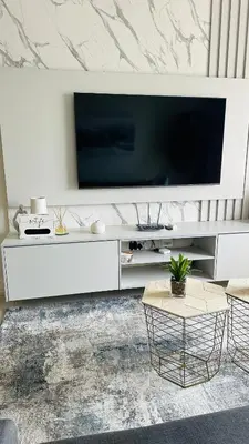 a living room with a large television and a table at Luxury Apartment at 93 on New in Midrand