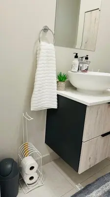 a bathroom with a sink and a mirror at Luxury Apartment at 93 on New in Midrand