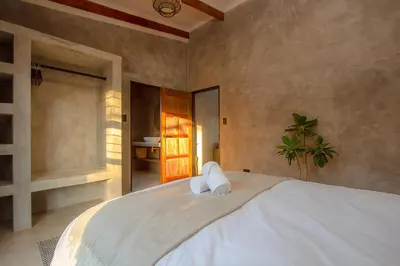 a bedroom with a large bed with two pillows on it at Pillows Luxury Safari Villa, Wood-Fired Hottub, Giraffe-Feeding-Tower, Large Private Pool in Marloth Park