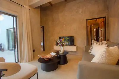 a living room with a couch and a table with a book at Pillows Luxury Safari Villa, Wood-Fired Hottub, Giraffe-Feeding-Tower, Large Private Pool in Marloth Park