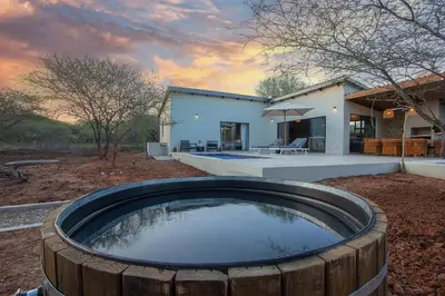 a large wooden tub in front of a house at Pillows Luxury Safari Villa, Wood-Fired Hottub, Giraffe-Feeding-Tower, Large Private Pool in Marloth Park
