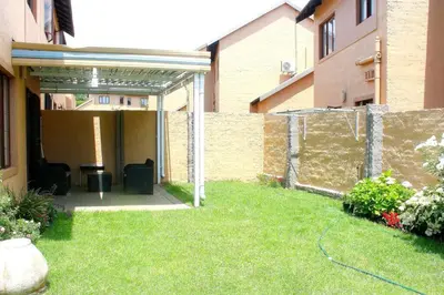 a backyard of a house with a fence at cozy 3 bed Duplex ,sleeps 6 with double bathroom in Midrand