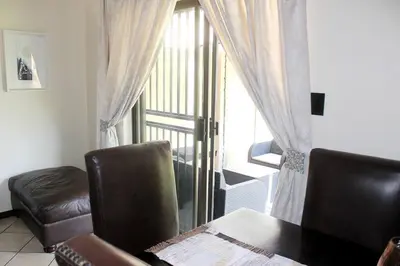 a living room with a chair and a table and a window at cozy 3 bed Duplex ,sleeps 6 with double bathroom in Midrand