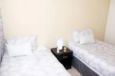 two beds sitting next to each other in a bedroom at cozy 3 bed Duplex ,sleeps 6 with double bathroom in Midrand