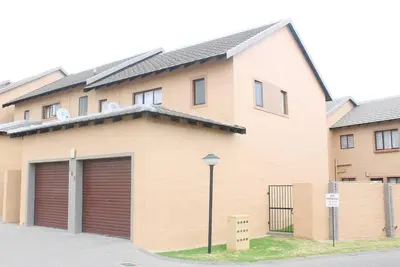 a building with two garage doors and a street light at cozy 3 bed Duplex ,sleeps 6 with double bathroom in Midrand
