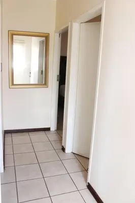 a hallway with a mirror and a tile floor at cozy 3 bed Duplex ,sleeps 6 with double bathroom in Midrand