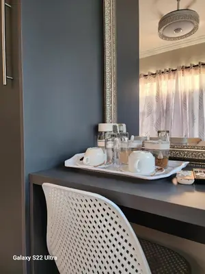 a table with a mirror and a white chair at Oblique Boutique House in Centurion