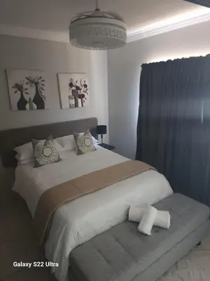 a bedroom with a large white bed with pillows at Oblique Boutique House in Centurion