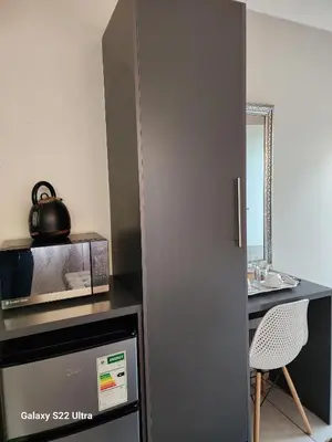 a kitchen with a microwave and a table with a chair at Oblique Boutique House in Centurion