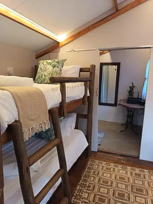 a room with bunk beds and a mirror at Koinonia Bush Lodge in Hartbeespoort